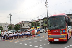 園児が見送るなかバスが出発する写真.JPG