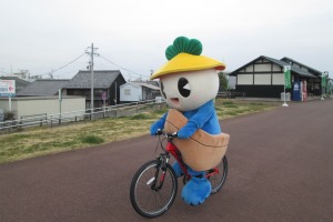 自転車に乗る町マスコットキャラクターのかさまるくん