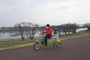 親子でタンデム自転車に乗る様子