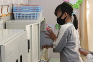 充電保管庫へタブレットを片付ける様子